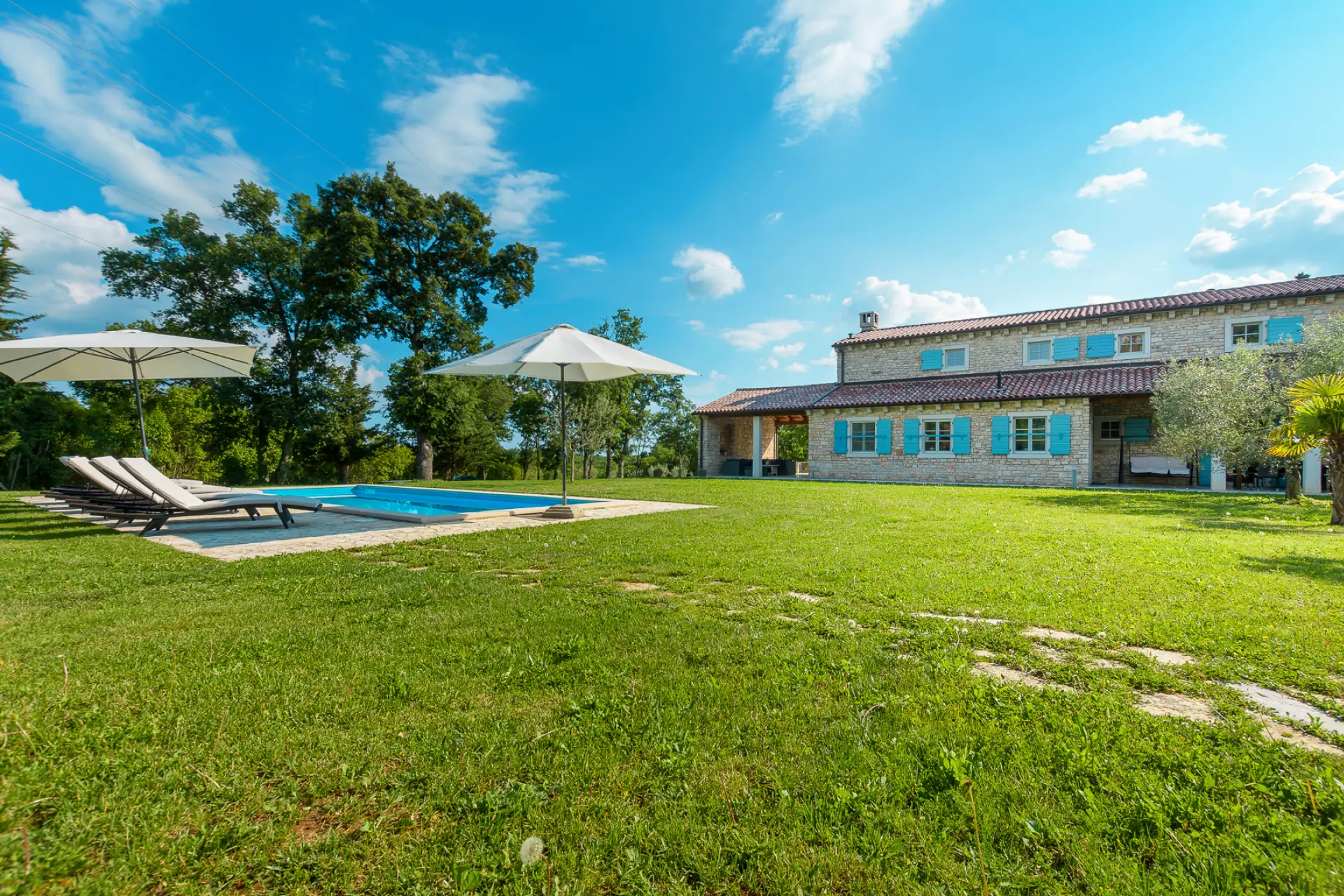 Country villa with a swimming pool under a blue sky